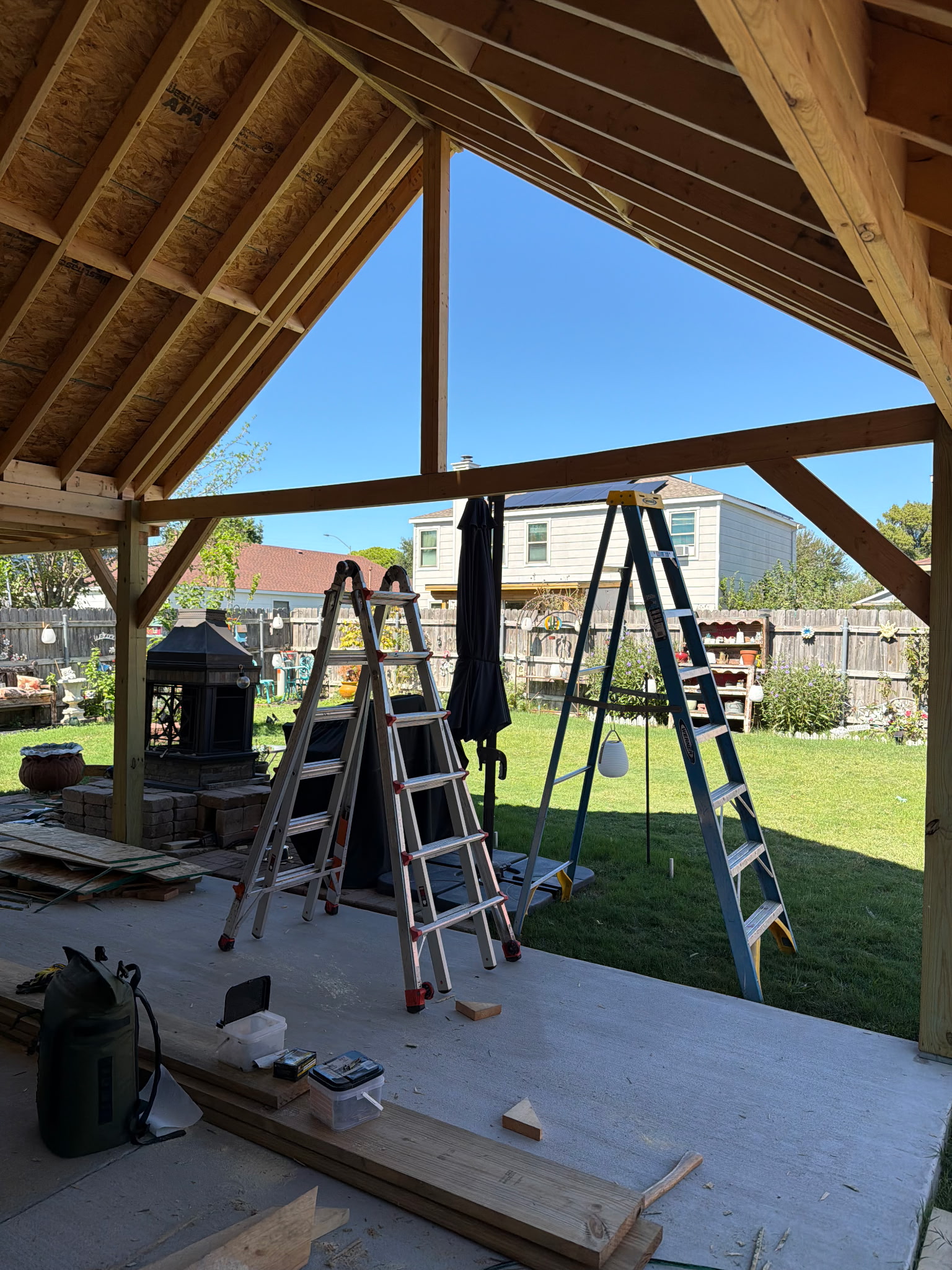 View under the patio roof with timber supports and ladders