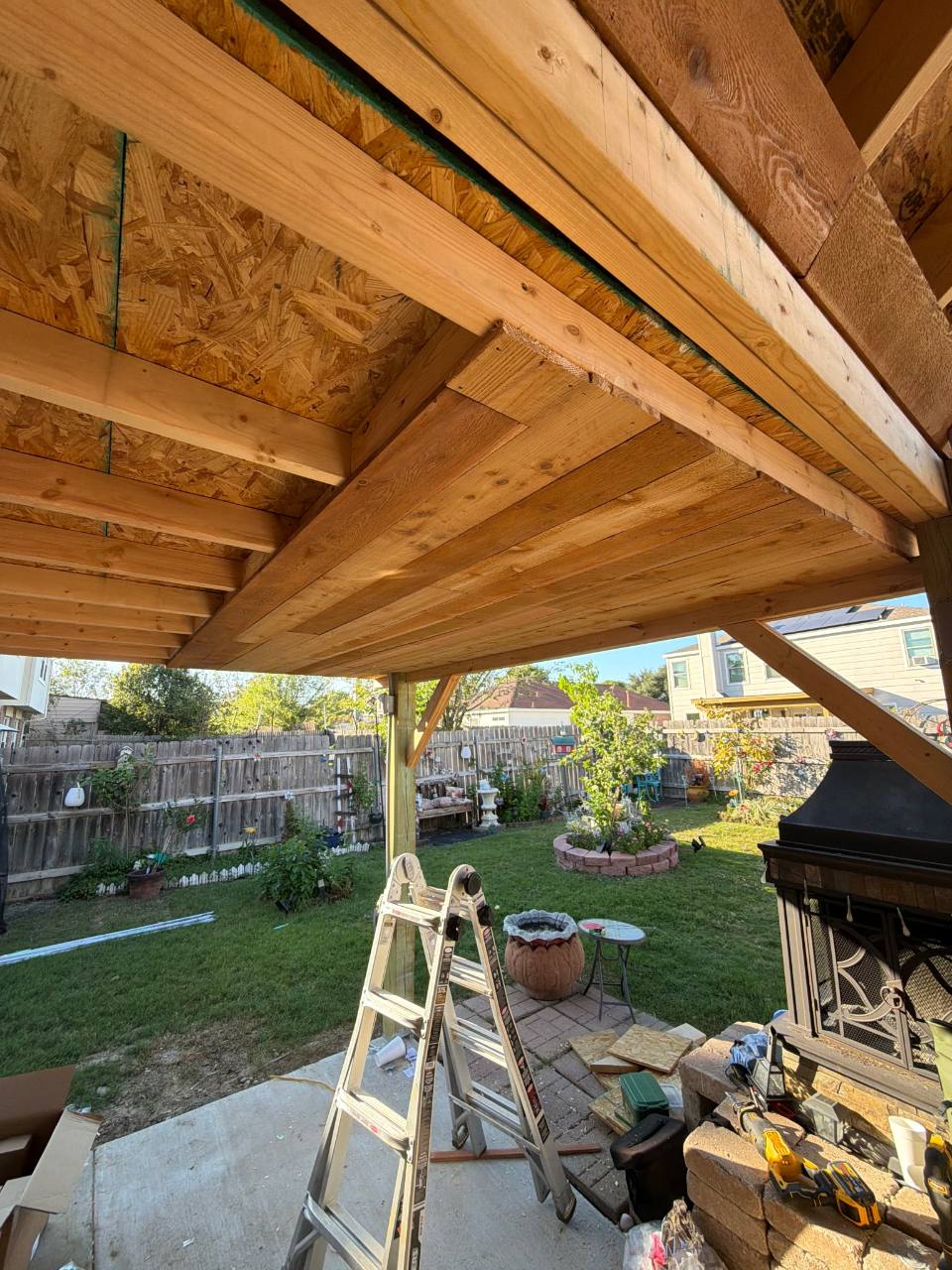 Timber beam and roof framing above a backyard patio
